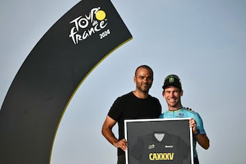 El ciclista británico del Astana Qazaqstan Team, Mark Cavendish, celebra, junto al exjugador de baloncesto francés Tony paker (i), las 35 victorias de etapa de su carrera.