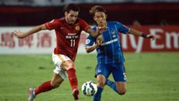 Ricardo Goulart y Usami Takashi enfrent&aacute;ndose por un bal&oacute;n en el choque del Guangzhou y Gamba Osaka.