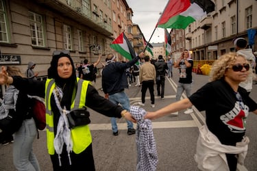 Los manifestantes que intentan pasar un cordón policial son retenidos por otros manifestantes, mientras la gente asiste a una protesta contra la participación de Israel en Eurovisión en Malmo, Suecia.