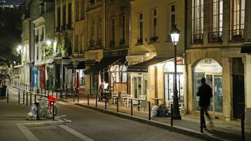 PARIS, FRANCE - OCTOBER 14: A man walks in a deserted street  as French President Emmanuel Macron deploys curfew amid accelerating coronavirus epidemic on October 14, 2020 in Paris, France. French President Emmanuel Macron announced on television this eve