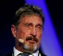 Why was John McAfee in exile and what was he being extradited for?
