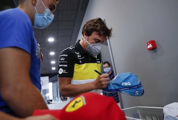 Fernando Alonso firma una gorra a un aficionado 