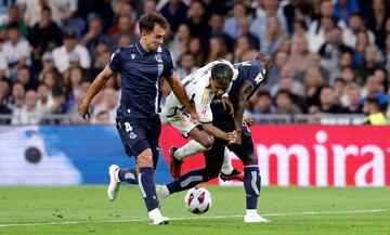 Rodrygo entre los jugadores de la Real Sociedad, Martín Zubimendi y Hamari Traore.