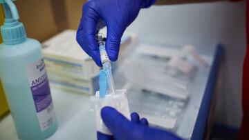 Un sanitario se prepara para administrar la vacuna contra la gripe.