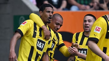 Dortmund's French forward Sebastien Haller (L) celebrates scoring the opening goal with his teammate Dortmund's Dutch forward Donyell Malen (C) and Dortmund's Portuguese defender Raphael Guerreiro during the German first division Bundesliga football match between FC Augsburg and BVB Borussia Dortmund in Augsburg, southern Germany, on May 21, 2023. (Photo by Christof STACHE / AFP) / DFL REGULATIONS PROHIBIT ANY USE OF PHOTOGRAPHS AS IMAGE SEQUENCES AND/OR QUASI-VIDEO