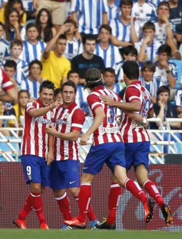 El delantero del Atlético de Madrid David Villa celebra con sus compañeros la consecución del primer gol de su equipo ante la Real Sociedad, durante el partido de la tercera jornada de liga en Primera División que se disputa esta tarde en el estadio Anoeta de San Sebastián.
