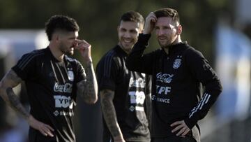 Argentina's forward Lionel Messi (R) gestures next to midfielder Rodrigo de Paul (L) and midfielder Leandro Paredes during a training session in Ezeiza, Buenos Aires on March 23, 2022, ahead of a FIFA World Cup Qatar 2022 qualifier footbal match against Venezuela to be held on March 25. (Photo by JUAN MABROMATA / AFP)