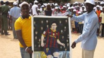 ÍDOLO. Dos seguidores de Leo Messi mostraron un retrato del jugador ayer, antes del acto en Saly.