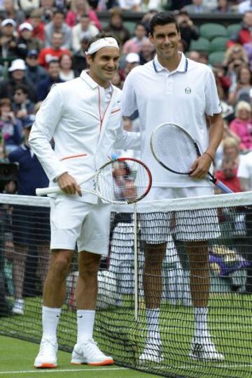 El suizo Roger Federer posa con el rumano Victor Hanescu en el inicio de su partido de primera ronda el primer día del Campeonato de Tenis de Wimbledon