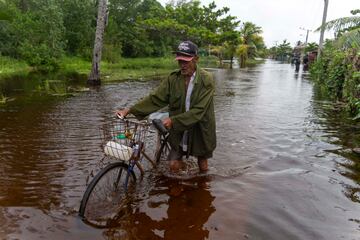 Un hombre empuja su bicicleta por una calle inundada tras el paso del huracán Helene por Guanimar, provincia de Artemisa, Cuba.