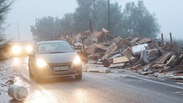 Cars move past damaged items from a furniture factory affected by torrential rains that caused flooding in La Alcudia, Valencia region, Spain, October 30, 2024. REUTERS/Eva Manez