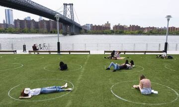 Brooklyn (United States), 18/05/2020.- People sit in socially-distanced circles painted on an open space in Domino Park in Brooklyn, New York, USA, 18 May 2020. (Abierto, Estados Unidos, Nueva York) EFE/EPA/JUSTIN LANE