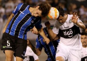 Omar Merlo disputa un cabezazo con Pablo Zeballos de Olimpia.