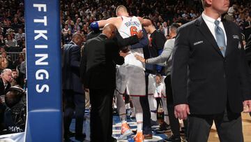 Kristaps Porzingis, ayudado por miembros de los New York Knicks, sale de la pista del Madison durante el encuentro de los Milwaukee Bucks.