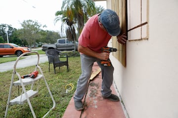 Ivaylo Kanchev cierra su casa con tablones antes de la llegada del huracán Milton en San Petersburgo, Florida.