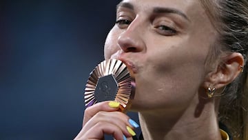 Bronze medallist Ukraine's Olga Kharlan celebrates on the podium during the medal ceremony for the women's sabre individual competition during the Paris 2024 Olympic Games at the Grand Palais in Paris, on July 29, 2024. (Photo by Fabrice COFFRINI / AFP)