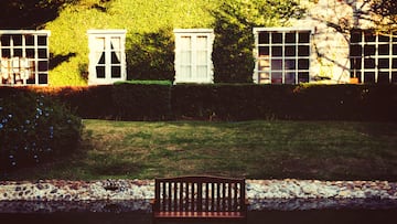 Bench for relax in front of the green grass yard