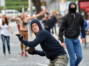 Un aficionado del Zorya Lugansk con un ladrillo en la mano para lanzarlo al cordón policial.