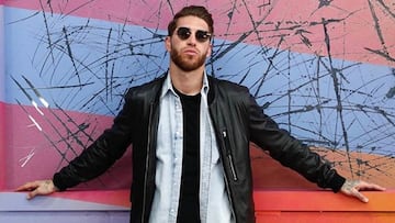 Sergio Ramos posando con gafas de sol frente a un colorido fondo.