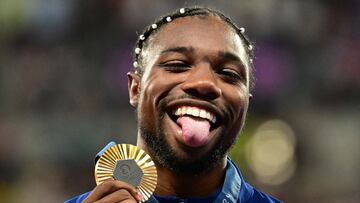 Gold medallist US' Noah Lyles celebrates on the podium during the victory ceremony for the men's 100m athletics event during the Paris 2024 Olympic Games at Stade de France in Saint-Denis, north of Paris, on August 5, 2024. (Photo by Martin BERNETTI / AFP)