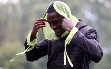 El defensa central del Liverpool llegó con esta apariencia misteriosa. Pero el misterio duró unos segundos, lo que tardó en desabrocharse su capucha.