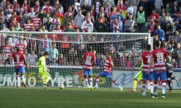 El delantero argentino del Barcelona Lionel Messi bate al portero del Granada Oier Olazábal y marca el tercer gol para el equipo, durante el partido de la vigésima quinta jornada de Liga de Primera División que se juega hoy en el estadio Nuevo Los Cármenes de Granada.