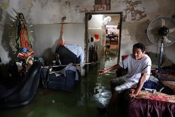 Aurelio Ortiz se sienta en su casa inundada después de que el huracán Milton trajera fuertes lluvias a la península de Yucatán en México en su camino a Florida.