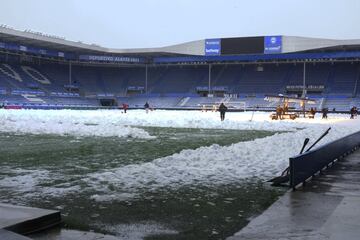 Operarios del club, ayudados con l¨¢mparas LED, eliminan la nieve del c¨¦sped del estadio de Mendizorroza.