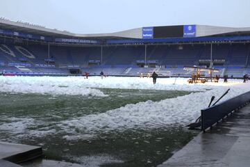 Operarios del club, ayudados con lámparas LED, eliminan la nieve del césped del estadio de Mendizorroza.