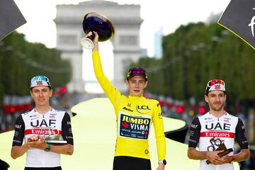 El ciclista danés de Jumbo-Visma Jonas Vingegaard con el maillot amarillo de líder general, el ciclista esloveno del UAE Team Emirates Tadej Pogacar en el segundo lugar general y el ciclista británico del UAE Team Emirates Adam Yates en el tercer lugar general celebra en el podio después de la etapa 21 y final de la 110 edición de la carrera ciclista del Tour de Francia,