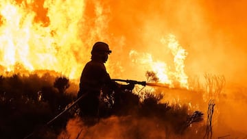 Firefighters operate at the site of a wildfire between Navalacruz and Riofrio near Avila, central Spain, on August 16, 2021. - A thousand people were evacuated and more than 5,000 hectares burned from 11am, with flames spreading up over a 40-kilometer per