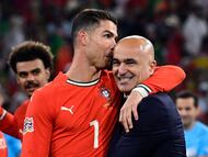 Portugal's forward #07 Cristiano Ronaldo and Portugal's Spanish head coach Roberto Martinez celebrate winning the UEFA Nations League final football match between Portugal and Spain in Munich, southern Germany on June 8, 2025. (Photo by John MACDOUGALL / AFP)