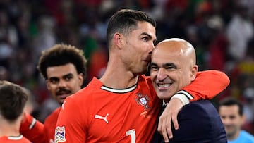 Portugal's forward #07 Cristiano Ronaldo and Portugal's Spanish head coach Roberto Martinez celebrate winning the UEFA Nations League final football match between Portugal and Spain in Munich, southern Germany on June 8, 2025. (Photo by John MACDOUGALL / AFP)