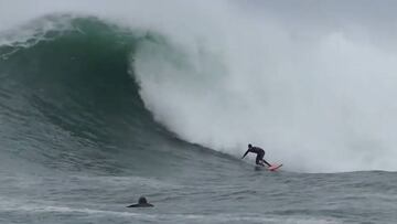 Lander S&aacute;nchez surfeando en invierno con su tabla roja en el mar Cant&aacute;brico.