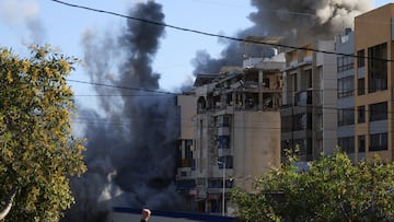 A person gestures as smoke rises from a building following an Israeli strike, amid escalating hostilities between Israel and Hezbollah, as the U.S.-Israel conflict with Iran continues, in Beirut, Lebanon, March 31, 2026. REUTERS/Mohamed Azakir