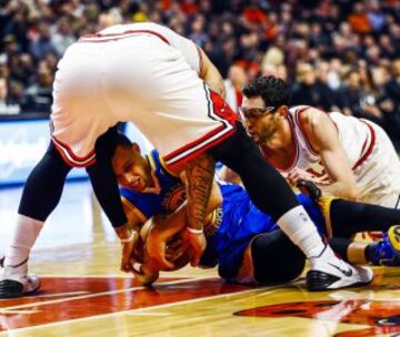 Stephen Curry disputa el balón con Kirk Hinrich y Carlos Boozer.
