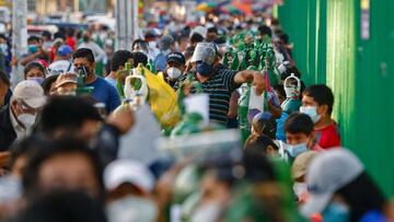 People wait to refill oxygen tanks in a queue of up to 200 people who camp outside a production plant, in San Juan de Lurigancho, Lima on February 19, 2021. - The shortage of medical oxygen in Peru, which makes relatives of COVID-19 patients have to search for it in different neighborhoods and queue for days, also forced authorities to accept assistance from neighboring Chile in order to meet the demand for critical patients. (Photo by Gian MAZCO / AFP)