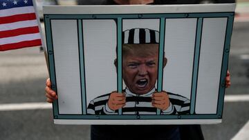 A demonstrator holds a sign of former U.S. President Donald Trump behind bars outside a courthouse in New York City, U.S., September 22, 2023.  REUTERS/Shannon Stapleton