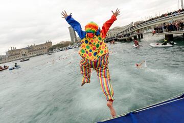 A participant in a clown suit jumps into the water during the 108th edition of the 'Copa Nadal' (Christmas Cup) swimming competition in Barcelona's Port Vell on December 25, 2017.  
The traditional 200-meter Christmas swimming race gathered more than 300 participants on Barcelona's old harbour.   / AFP PHOTO / Josep LAGO