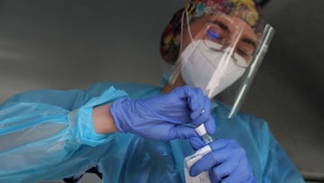 A healthcare worker handles a sample taken from a woman for a coronavirus disease (COVID-19) test, at a mobile testing truck, in Santiago, Chile, January 31, 2022. REUTERS/Ivan Alvarado