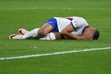 Kylian Mbappé tumbado en el césped tras recibir el impacto que le ocasiona una herida en el tabique nasal.