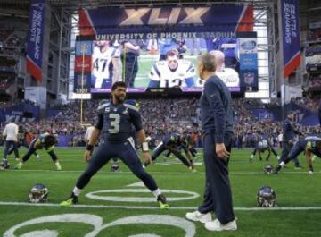 El quarterback Russell Wilson Seattle Seahawks conversa con su entrenador  Pete Carroll en el calentamiento.