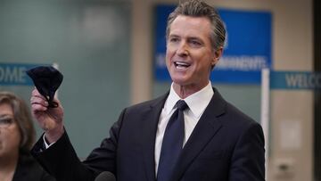 El gobernador Gavin Newsom sostiene una mascarilla mientras habla en una conferencia de prensa en Oakland, California, el lunes 26 de julio de 2021. 