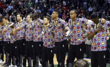 Los jugadores de los Milwaukee Bucks durante el minuto de silencio en homenaje a Craig Sager, periodista de la TNT, conocido por sus inconfundibles y extravagantes chaquetas, que falleció tras más de 2 años de lucha contra la leucemia.
