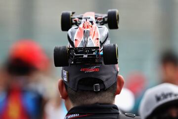 Un aficionado lleva una r谷plica del monoplaza de Fernando Alonso decorando su sombrero.
