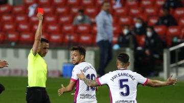 Referee Santiago Jaime Latre shows a red card to Valladolid's Oscar Plano after he tackled Barcelona's Ousmane Dembele during the Spanish La Liga soccer match between FC Barcelona and Valladolid CF at the Camp Nou stadium in Barcelona, Spain, Mo