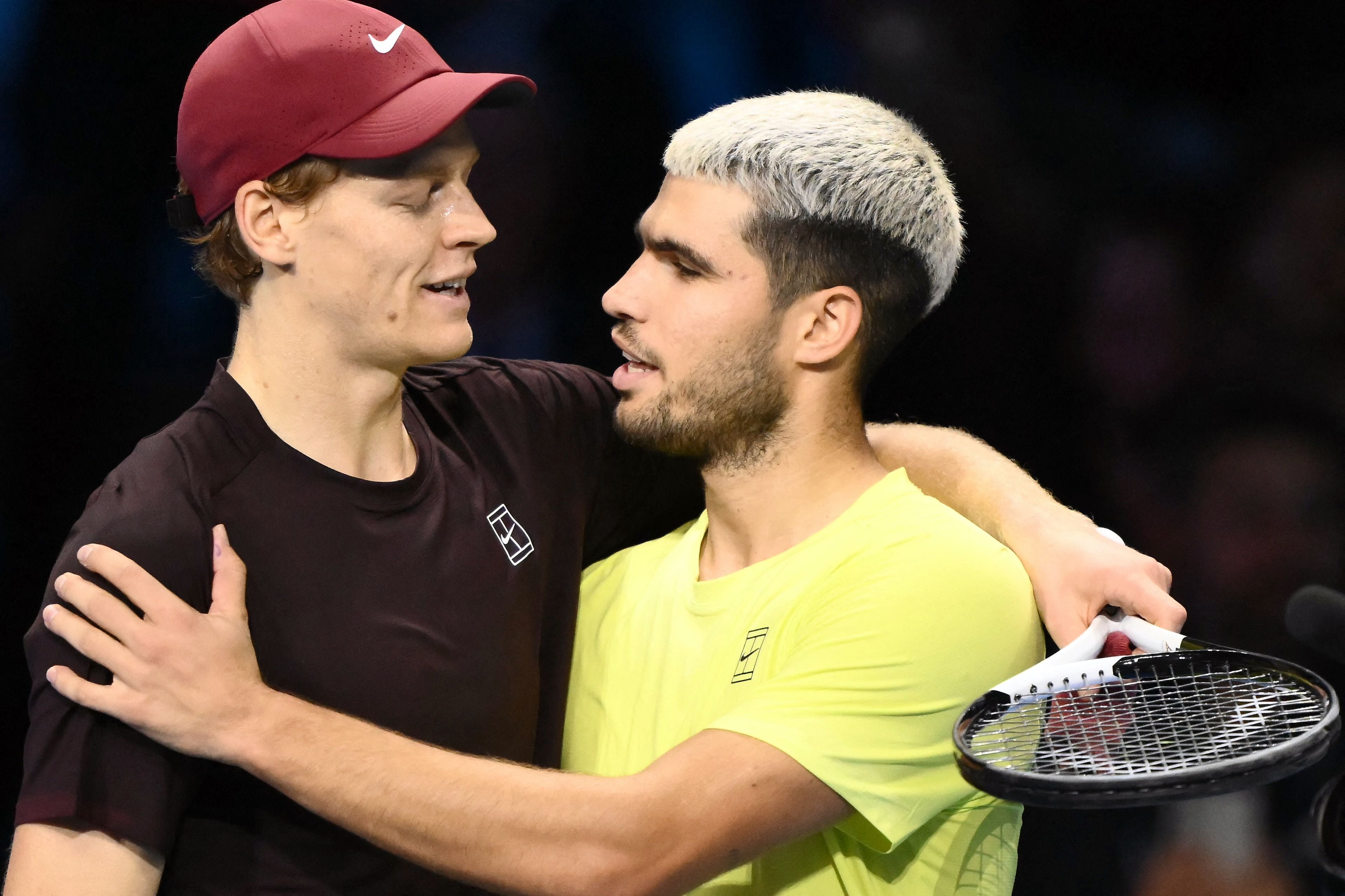 (FILES) Italy's Jannik Sinner (L) is congratulated by Spain's Carlos Alcaraz at the end of their men's single final match at the ATP Finals tennis tournament, in Turin, on November 16, 2025. Carlos Alcaraz and Jannik Sinner are gearing up for more world domination in 2026, starting at the Australian Open, while Aryna Sabalenka is bubbling with confidence as she chases further Grand Slam success. (Photo by Marco BERTORELLO / AFP)
