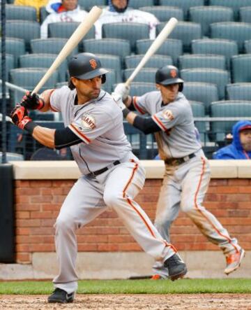 Ángel Pagan de los San Francisco Giants en el partido ante los New York Mets, mientras su compañero Matt Duffy calienta el bateo en la zona de banquillo.