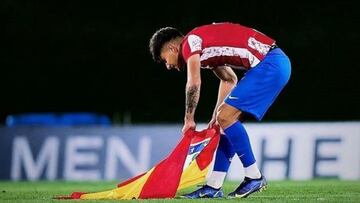 Carlos Martín depositando una bandera del Atlético en Valdebebas tras el triunfo ante el Madrid juvenil en la Youth Ligue 21-22.