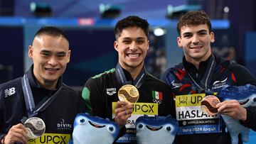 Australia's silver-medallist Shixin Li, Mexico's gold medallist Osmar Olvera Ibarra, and Britain's bronze-medallist Ross Haslam pose for a picture with their medals on the podium after the final of the men's 1m springboard diving event during the 2024 World Aquatics Championships at Hamad Aquatics Centre in Doha on February 3, 2024. (Photo by SEBASTIEN BOZON / AFP)